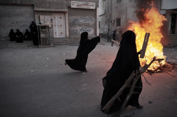 Bahraini women throw wood onto a fire during clashes with and riot police following a protest in the village of Al-Maqsha, west of Manama, on April 25, 2014 Bahraini women throw wood onto a fire during clashes with and riot police following a protest in the village of Al-Maqsha, west of Manama, on April 25, 2014