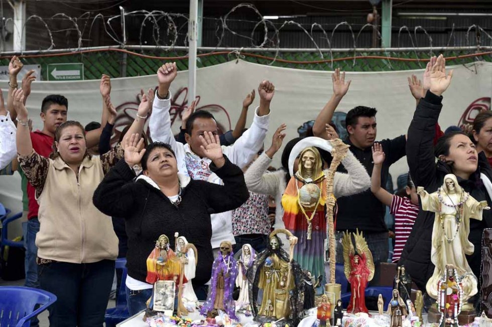 Devotees pray in front of Santa Muerte figures. Tultitlan, February, 2016. Devotees pray in front of Santa Muerte figures. Tultitlan, February, 2016.