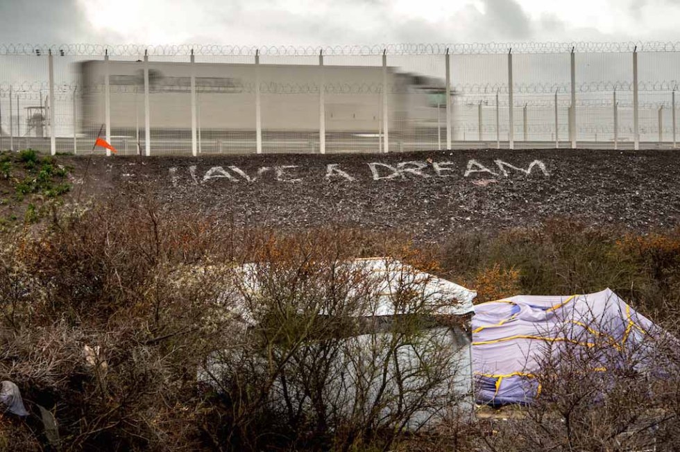 A lorry speeds by the Jungle where people have come with the dream of reaching Britain. January, 2016. A lorry speeds by the Jungle where people have come with the dream of reaching Britain. January, 2016.