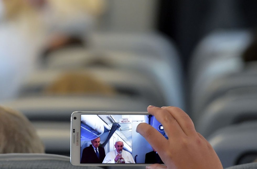 A journalist takes pictures of the Pope on a plane to Quito on July 5, 2015 A journalist takes pictures of the Pope on a plane to Quito on July 5, 2015