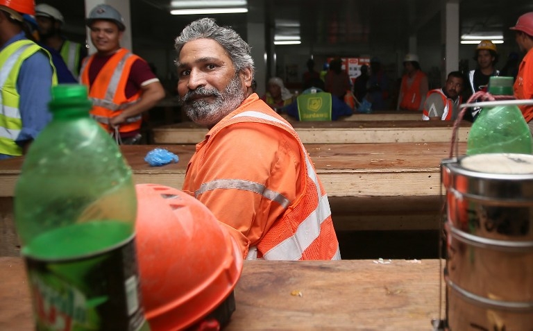 A migrant labourer breaks for lunch on a Doha construction site in October 2013 A migrant labourer breaks for lunch on a Doha construction site in October 2013