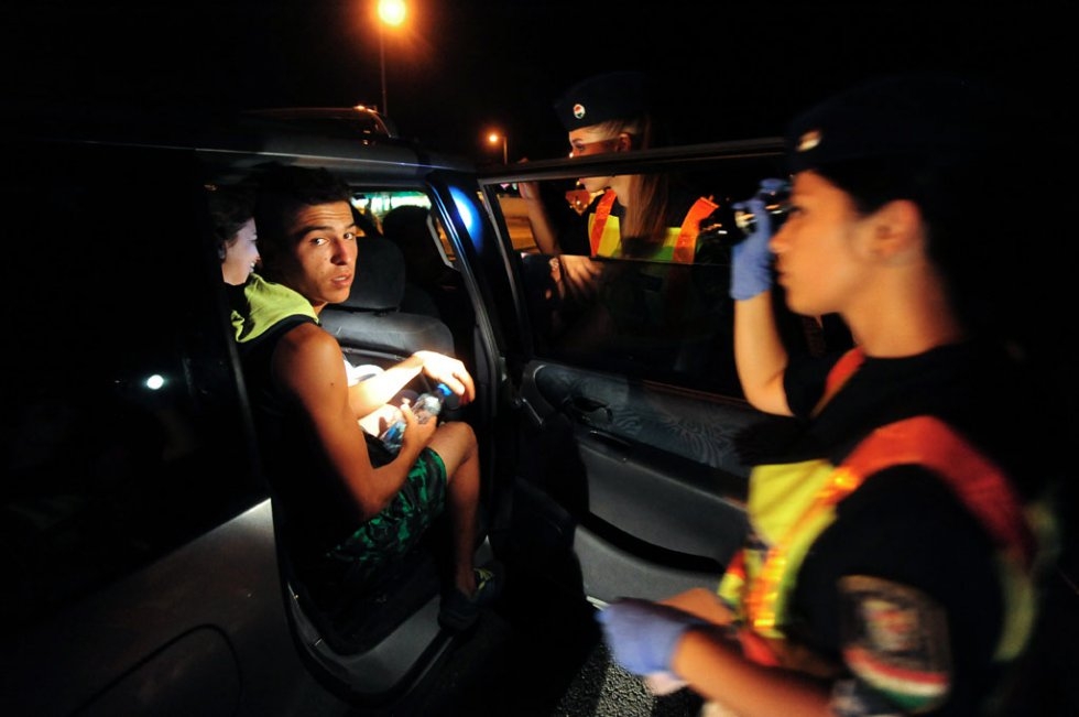 Hungarian police officers inspect the car of a suspected smuggler on a highway between the Serbian border and Budapest near Szatymaz on September 3, 2015 Hungarian police officers inspect the car of a suspected smuggler on a highway between the Serbian border and Budapest near Szatymaz on September 3, 2015