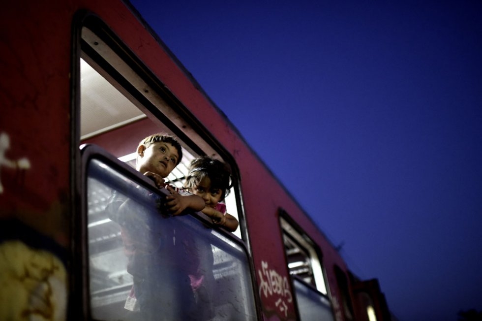 Children look outside a train window after crossing the border from Greece to Macedonia on August 29, 2015 Children look outside a train window after crossing the border from Greece to Macedonia on August 29, 2015