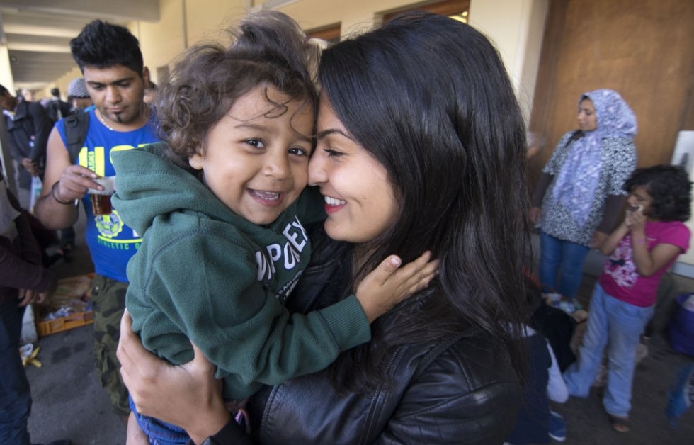 An Austrian volunteer plays with a 3-year old Afghan girl at Vienna's Westbahnhof station on September 6, 2015 An Austrian volunteer plays with a 3-year old Afghan girl at Vienna's Westbahnhof station on September 6, 2015