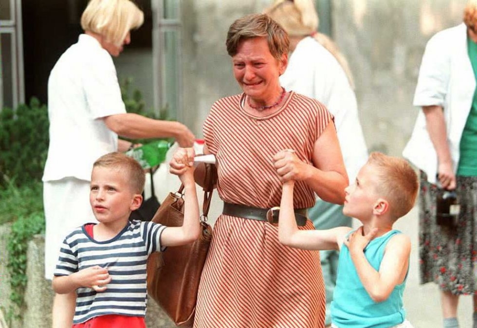 A whoman whose husband was wounded by a shell leaves Sarajevo's Kosevo hospital with her children on July 21, 1995 A whoman whose husband was wounded by a shell leaves Sarajevo's Kosevo hospital with her children on July 21, 1995