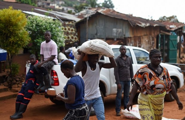 Members of a Sierra Leonean family carry supplies delivered by the UN's World Food Program as they observe a quarantine at home in the Dwarzac neighbourhood in Freetown, on November 7, 2014 (AFP PHOTO/ FRANCISCO LEONG) Members of a Sierra Leonean family carry supplies delivered by the UN's World Food Program as they observe a quarantine at home in the Dwarzac neighbourhood in Freetown, on November 7, 2014 (AFP PHOTO/ FRANCISCO LEONG)
