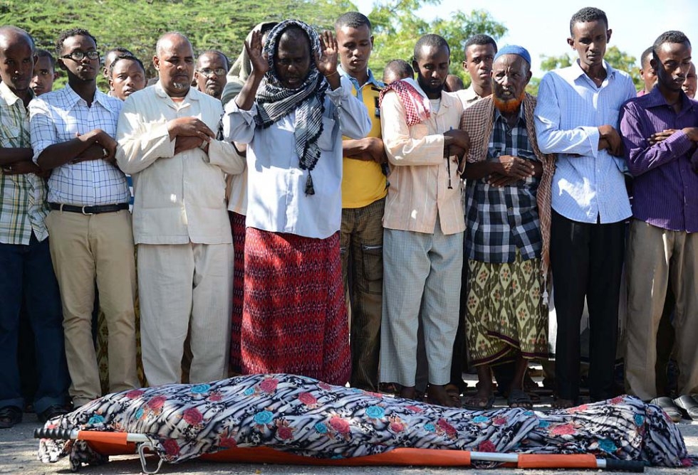 "Relatives and fellow journalists pray over the body of Mohamed Mohamud Timacade, a reporter with London-based Somali-language Universal TV, who was shot dead in Mogadishu, on October 27, 2013 "Relatives and fellow journalists pray over the body of Mohamed Mohamud Timacade, a reporter with London-based Somali-language Universal TV, who was shot dead in Mogadishu, on October 27, 2013