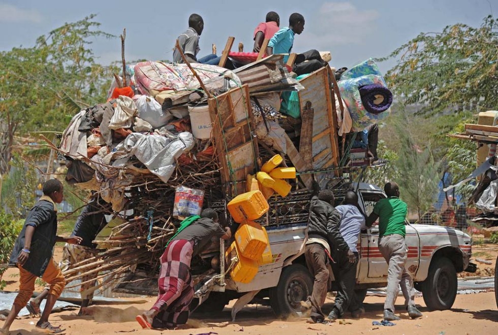 Somali refugees carry their belongings after their temporary shelters were destroyed by the army on March 4, 2015 at the Sarkusta camp in Mogadishu Somali refugees carry their belongings after their temporary shelters were destroyed by the army on March 4, 2015 at the Sarkusta camp in Mogadishu