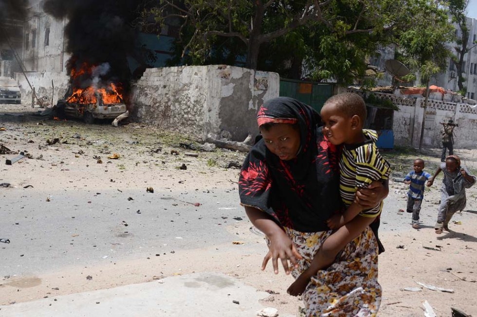 A mother runs with her child on April 14, 2013, in Mogadishu, after a suicide bomber attack in the regional court premises that left several dead (AFP Photo / Mohamed Abdiwahab) A mother runs with her child on April 14, 2013, in Mogadishu, after a suicide bomber attack in the regional court premises that left several dead (AFP Photo / Mohamed Abdiwahab)