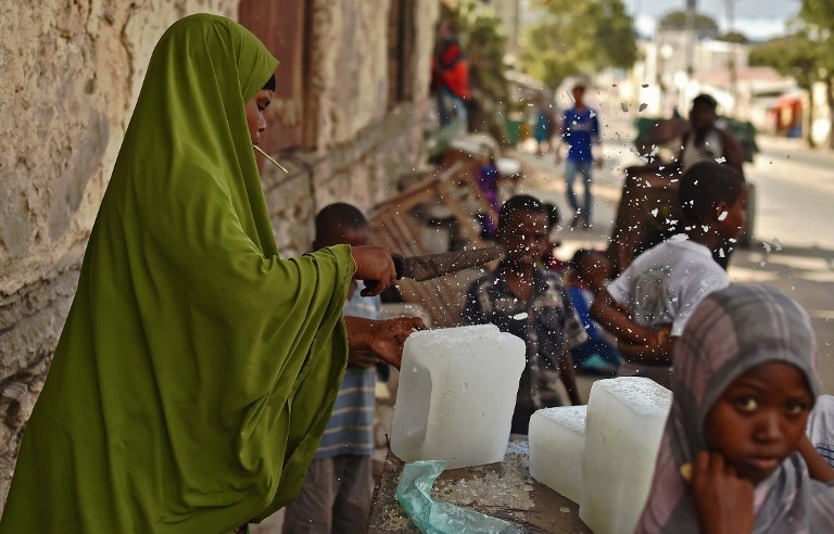 A woman cuts blocks of ice in Mogadishu on March 26, 2015 A woman cuts blocks of ice in Mogadishu on March 26, 2015