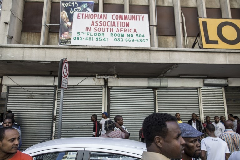 Foreigners stand in front of closed foreign-owned stores in Johannesburg on April 15, 2015 Foreigners stand in front of closed foreign-owned stores in Johannesburg on April 15, 2015