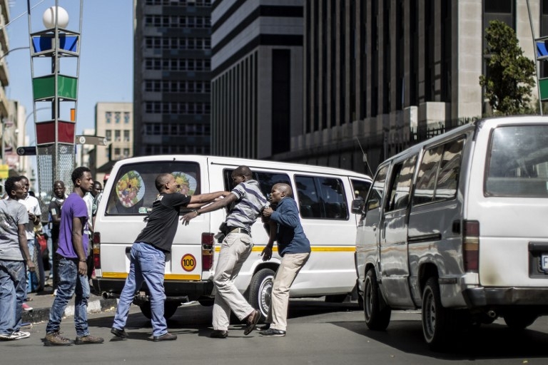 A South African taxi driver is pushed around by immigrants after making xenophobic remarks during a traffic incident in Johannesburg on April 15, 2015 A South African taxi driver is pushed around by immigrants after making xenophobic remarks during a traffic incident in Johannesburg on April 15, 2015