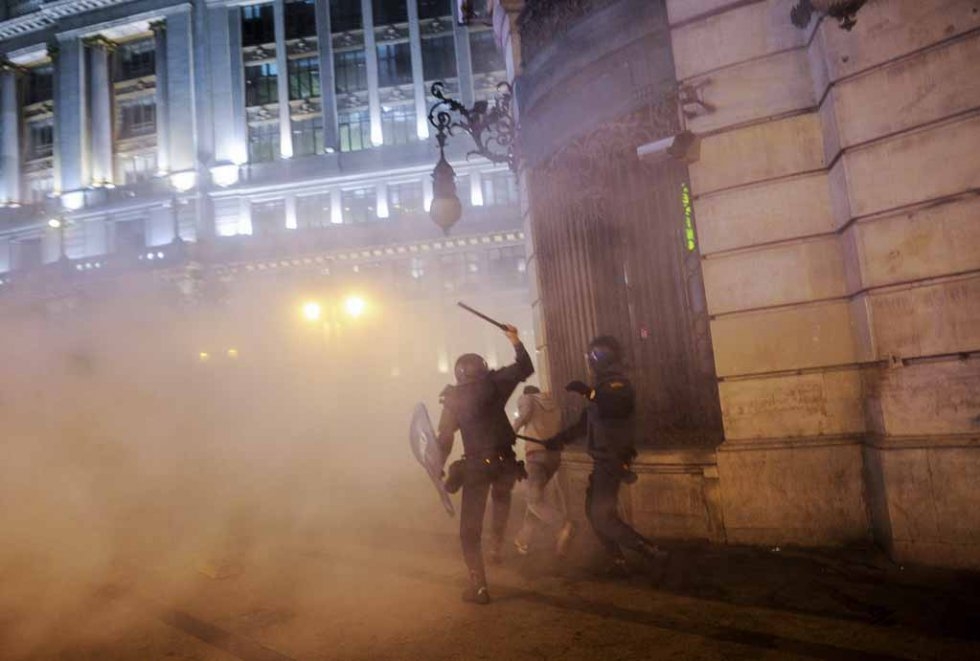 Riot police chase a protester in Madrid in 2012. Riot police chase a protester in Madrid in 2012.