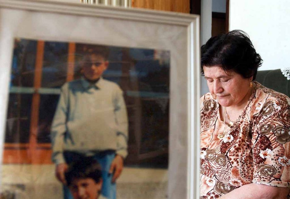 Bosnian Muslim Nura Alispahic, formerly of Srebrenica, is shown at her home in Tuzla on 04 June 2005 beside a picture of her son who was shot dead by Serb forces 10 years earlier Bosnian Muslim Nura Alispahic, formerly of Srebrenica, is shown at her home in Tuzla on 04 June 2005 beside a picture of her son who was shot dead by Serb forces 10 years earlier