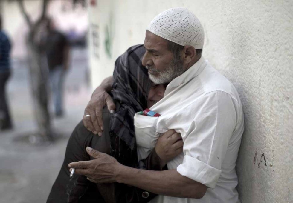 A couple comforts each other after losing relatives in an Israeli air strike. A couple comforts each other after losing relatives in an Israeli air strike.