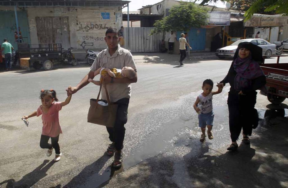 Families flee their homes in southern Gaza following Israeli air strikes in the area. August, 2014. Families flee their homes in southern Gaza following Israeli air strikes in the area. August, 2014.