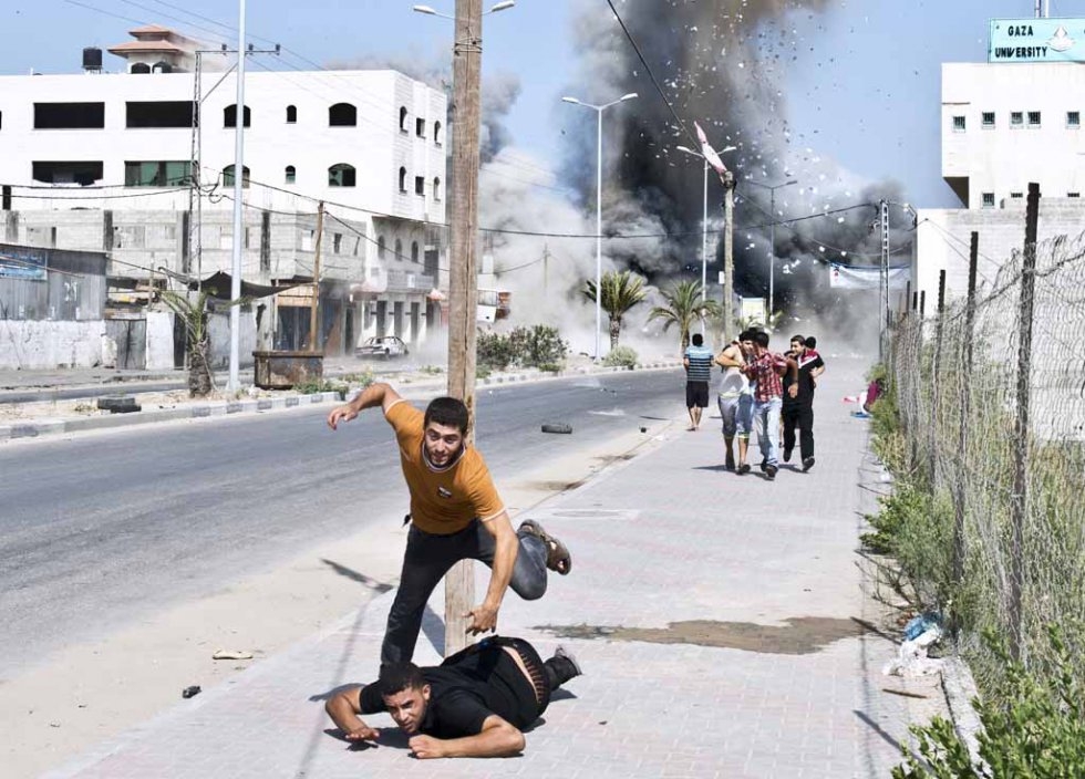 Palestinians scramble after an air strike on a house in Gaza. August, 2014. Palestinians scramble after an air strike on a house in Gaza. August, 2014.