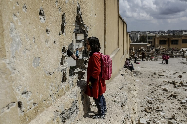 A Syrian schoolgirl beside a damaged wall at her school in Kobane on March 25, 2015 A Syrian schoolgirl beside a damaged wall at her school in Kobane on March 25, 2015