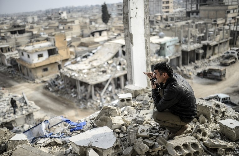 A Kurdish man talks with a radio as he checks the eastern part of Kobane, Syria on January 28, 2015 A Kurdish man talks with a radio as he checks the eastern part of Kobane, Syria on January 28, 2015