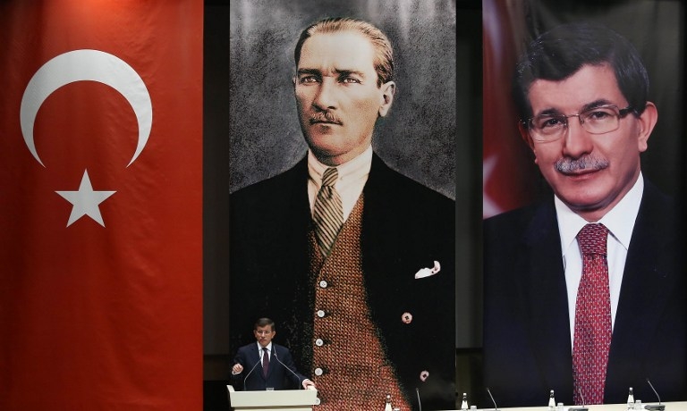 Turkish Prime Minister Ahmet Davutoglu delivers a speech below portraits of himself and Mustafa Kemal Ataturk, the founder of modern-day Turkey, in Ankara on May 20, 2015 Turkish Prime Minister Ahmet Davutoglu delivers a speech below portraits of himself and Mustafa Kemal Ataturk, the founder of modern-day Turkey, in Ankara on May 20, 2015