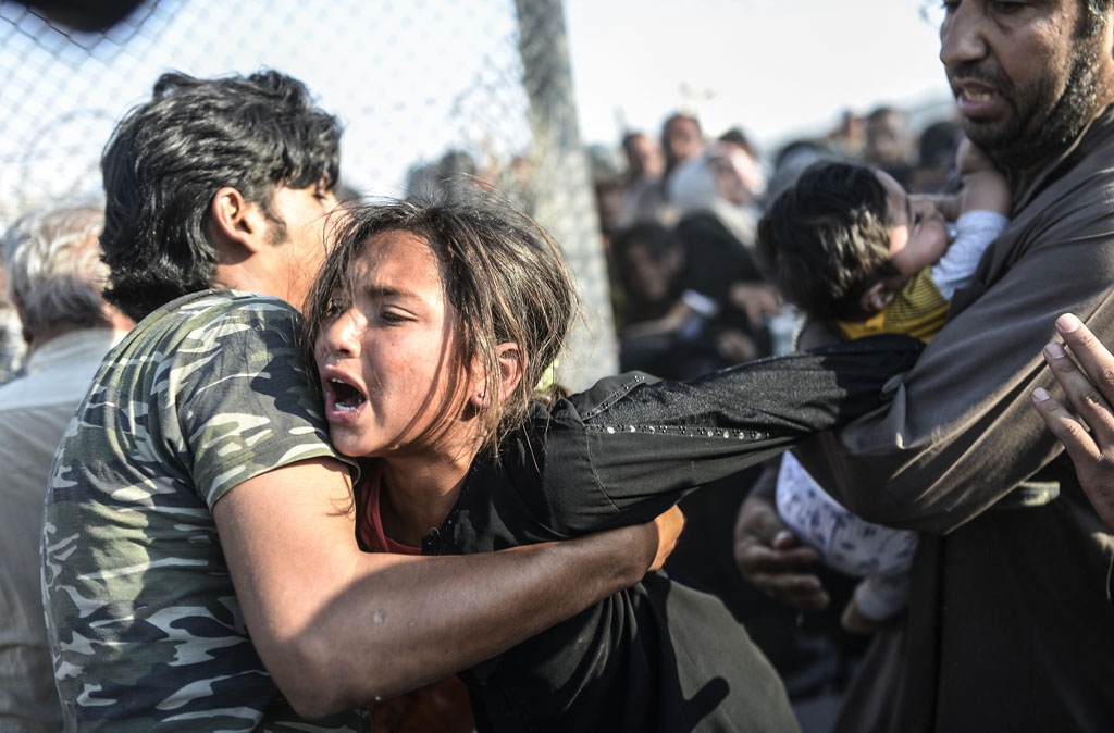 Syrians fleeing the war rush through broken down border fences to enter Turkish territory, near the border crossing at Akcakale in Sanliurfa province on June 14, 2015 Syrians fleeing the war rush through broken down border fences to enter Turkish territory, near the border crossing at Akcakale in Sanliurfa province on June 14, 2015