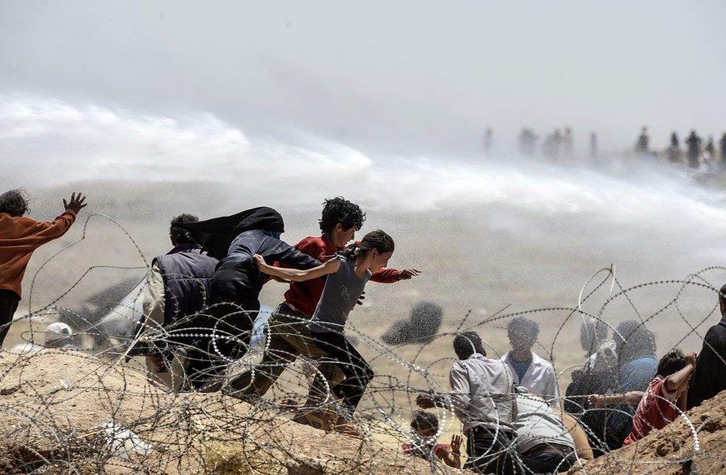 Turkish soldiers use water cannon to move Syrian refugees from border fences at Akcakale in Sanliurfa province, on June 13, 2015 Turkish soldiers use water cannon to move Syrian refugees from border fences at Akcakale in Sanliurfa province, on June 13, 2015