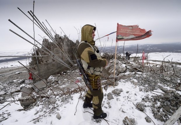 A Donetsk People's Republic fighter looks out over the damaged Savur-Mogyla memorial A Donetsk People's Republic fighter looks out over the damaged Savur-Mogyla memorial