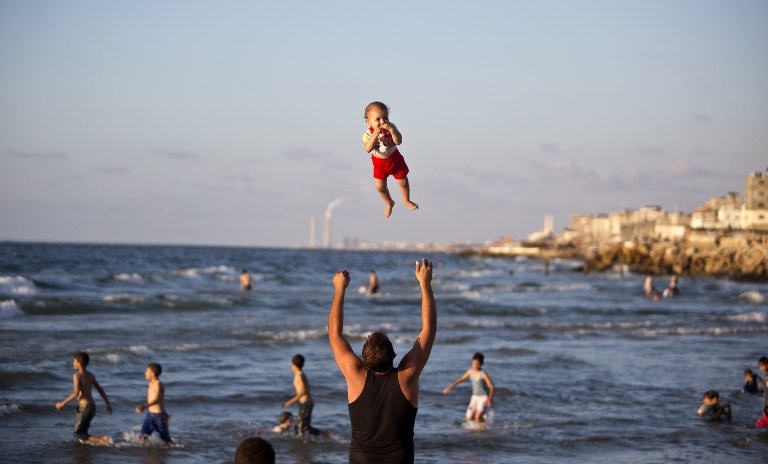 A man and his baby on a beach in Gaza City on September 7, 2014 A man and his baby on a beach in Gaza City on September 7, 2014