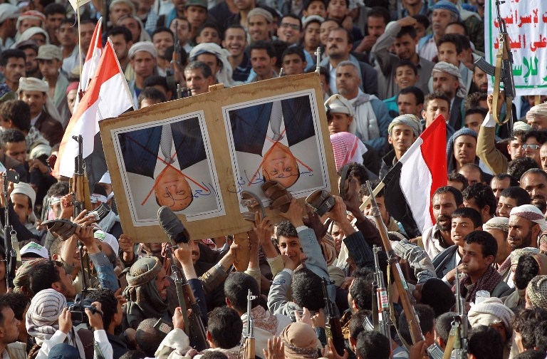Tribal gunmen loyal to the Huthi movement deface a portrait of Yemeni President Abedrabbo Mansour Hadi with shoes in the capital Sanaa on April 1, 2015 Tribal gunmen loyal to the Huthi movement deface a portrait of Yemeni President Abedrabbo Mansour Hadi with shoes in the capital Sanaa on April 1, 2015