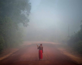 Tribal chieftain Tzako Waiapi walks in the fog at the Manilha village in Waiapi indigenous reserve in Amapa state in Brazil on October 13, 2017.  Tzako Waiapi perfectly remembers the day almost half a century ago when his hunting party stumbled across a g