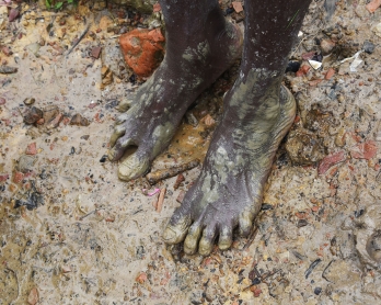 A Rohingya refugee walks in the mud at Thangkhali refugee camp in Bangladesh's Cox's Bazar district on September 17, 2017.