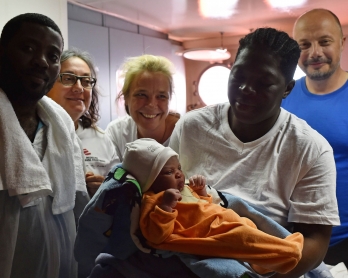 Bernadette Obiona and David Dibonde (L) pose with their newborn Alex with Angelina Perri from Italy (2ndL), a nurse working for French NGO Medecins Sans Frontieres, doctor Erna Rijnierse (C) from Netherlands and the captain of the 