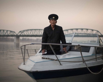Sailor Kim Il-Soo poses for a phot on a boat used to host wedding photo shoots on the Taedong river in Pyongyang.