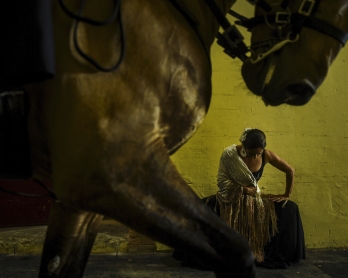 A horseman rides past a dancer warming up backstage during the Bullfighting Day at the Campo Pequeno bullfighting arena in Lisbon on February 23, 2019. - The 'Corrida' explained to children, followed by a bloodless show: bullfighters in Portugal are tryin