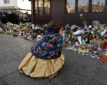 A child outside a memorial to victims at the Petit Cambodge restaurant. (AFP/Alain Jocard)