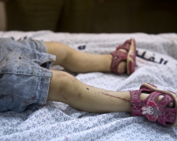 A one-and-a-half year old Palestinian girl lies on a table at a local morgue after she was killed by an Israeli airstrike while walking a block from her house with her mother in Gaza City on August 24, 2014 (AFP Photo / Roberto Schmidt)
